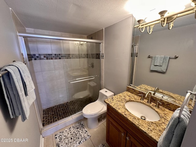 full bath featuring toilet, a stall shower, vanity, a textured ceiling, and tile patterned floors