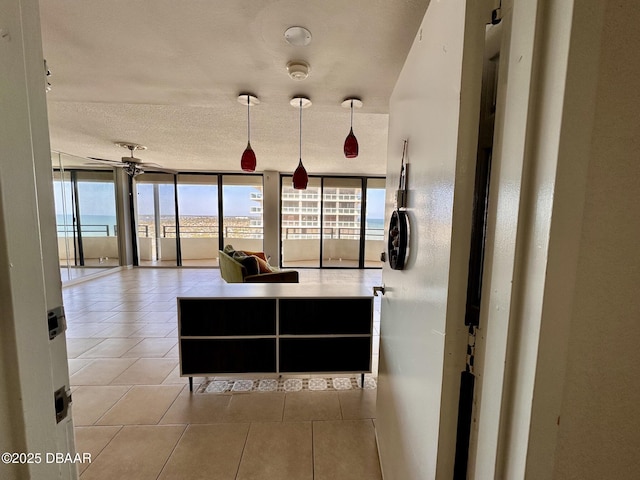 kitchen featuring floor to ceiling windows, a healthy amount of sunlight, a textured ceiling, and tile patterned floors