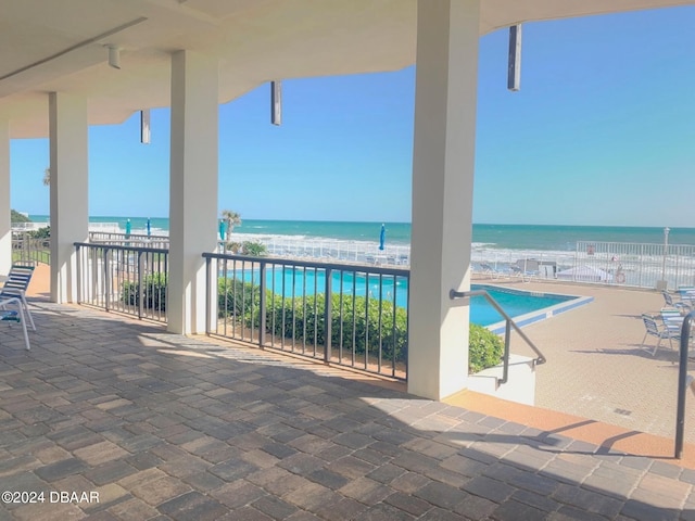 view of patio featuring a water view and a balcony