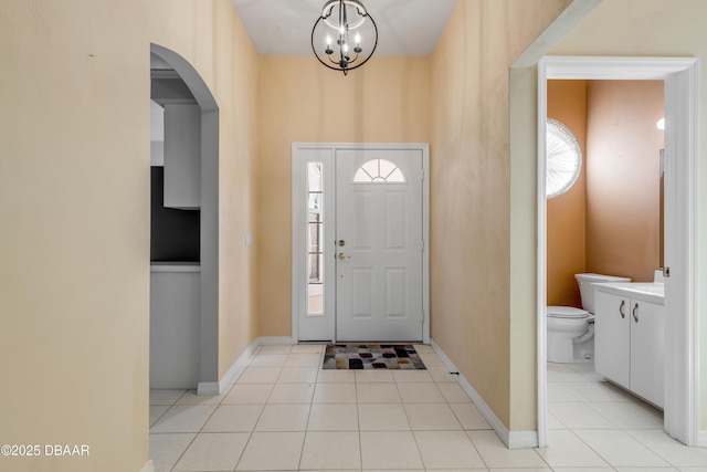 tiled entrance foyer featuring an inviting chandelier