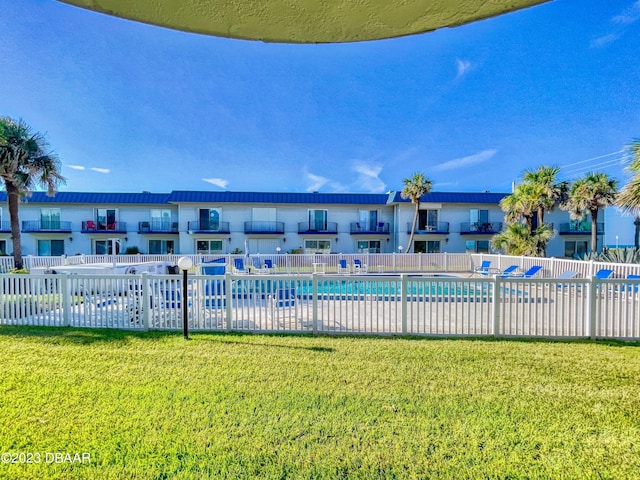 pool featuring fence and a lawn