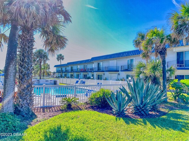 community pool with a yard and fence