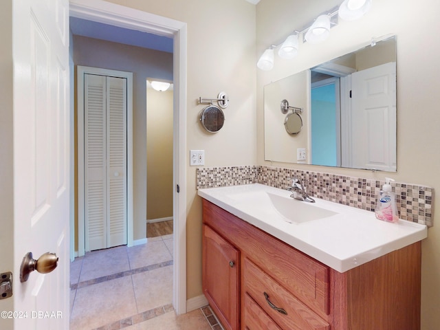 bathroom featuring tile patterned flooring, decorative backsplash, and vanity