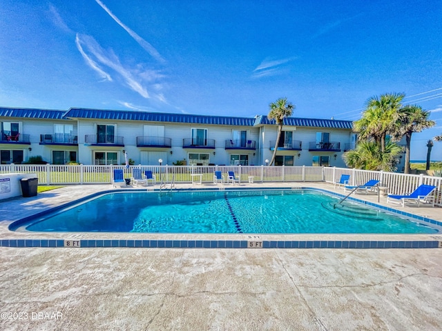 community pool with fence and a patio