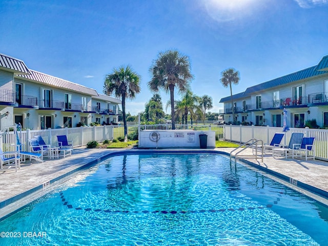 pool featuring a residential view, fence, and a patio