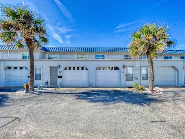 townhome / multi-family property with aphalt driveway and stucco siding