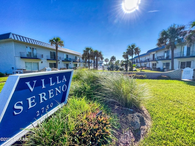 community / neighborhood sign featuring a residential view and a lawn