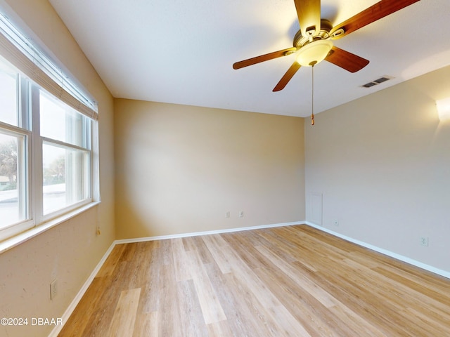 unfurnished room featuring a ceiling fan, light wood-type flooring, visible vents, and baseboards