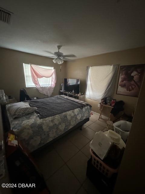 tiled bedroom featuring ceiling fan