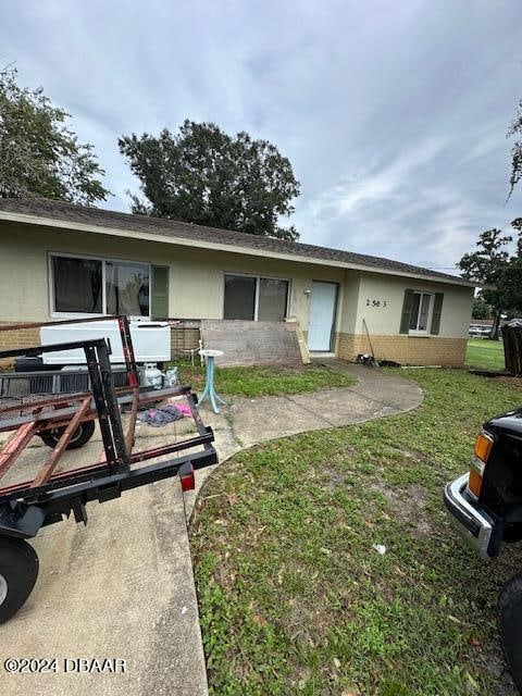 view of front of home featuring a front yard and a patio