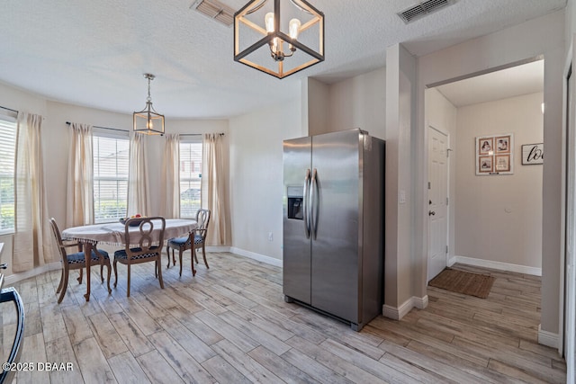 1743 Savannah Ln, Port Orange, FL 32128 - dining area with light wood-style flooring, a chandelier, and a textured ceiling