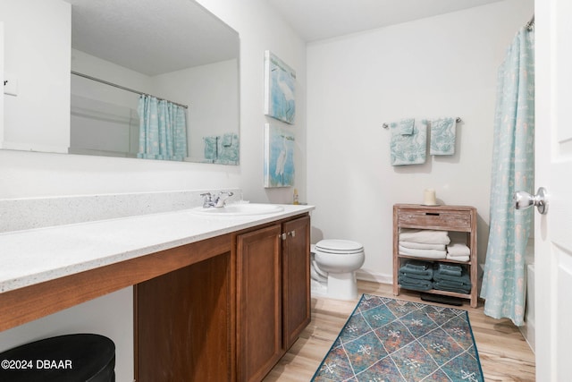 full bathroom with wood-type flooring, vanity, toilet, and shower / tub combo