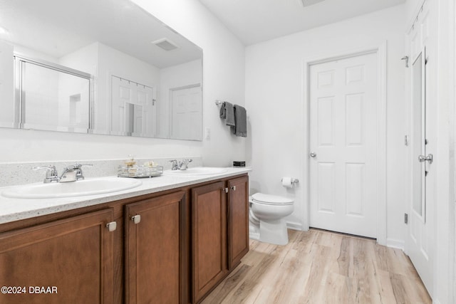 bathroom featuring hardwood / wood-style floors, an enclosed shower, vanity, and toilet