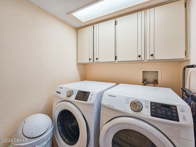 washroom with cabinets, separate washer and dryer, and a textured ceiling