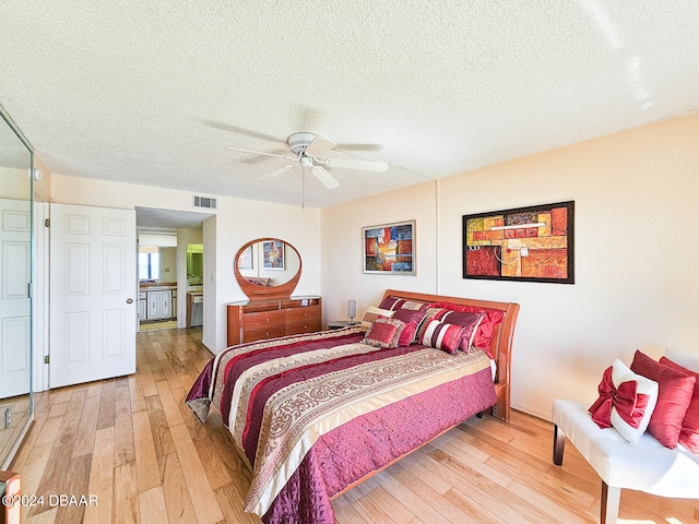 bedroom featuring hardwood / wood-style flooring, ceiling fan, and a textured ceiling