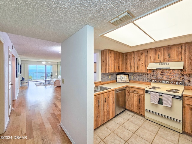 kitchen featuring light hardwood / wood-style floors, a textured ceiling, backsplash, stainless steel dishwasher, and range with electric stovetop