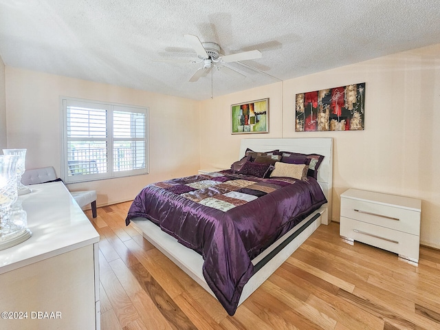 bedroom featuring ceiling fan, a textured ceiling, and light hardwood / wood-style floors