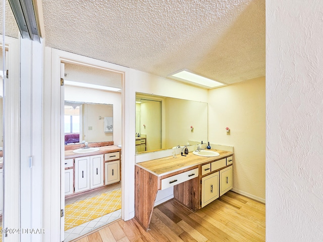 bathroom featuring a textured ceiling, vanity, and hardwood / wood-style flooring