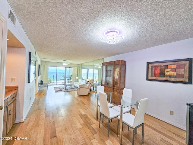 dining area featuring ceiling fan, a textured ceiling, and light wood-type flooring