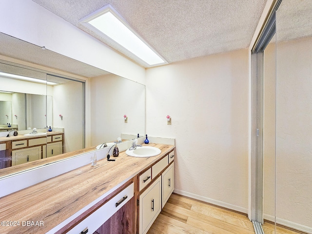 bathroom featuring vanity, a textured ceiling, and hardwood / wood-style flooring