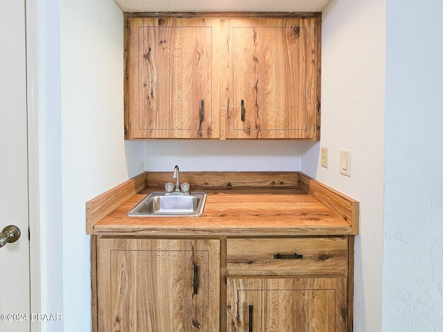 bar with a textured ceiling and sink