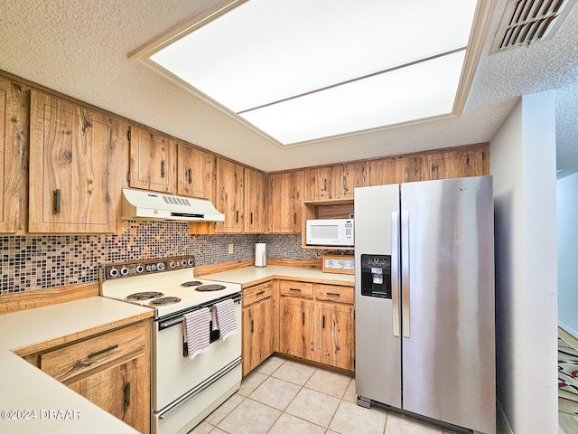 kitchen featuring decorative backsplash, a textured ceiling, white appliances, and light tile patterned flooring