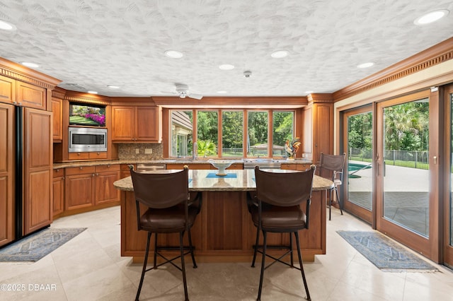 1010/1020 Big Tree Rd, Daytona Beach, FL 32119 - kitchen featuring built in appliances, plenty of natural light, brown cabinets, recessed lighting, and ornamental molding
