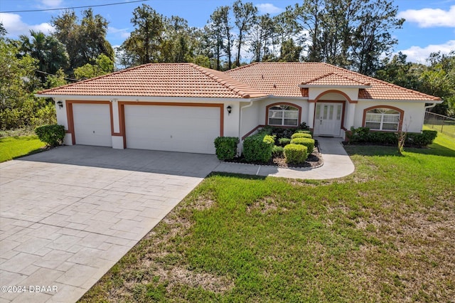 mediterranean / spanish home with a garage and a front yard