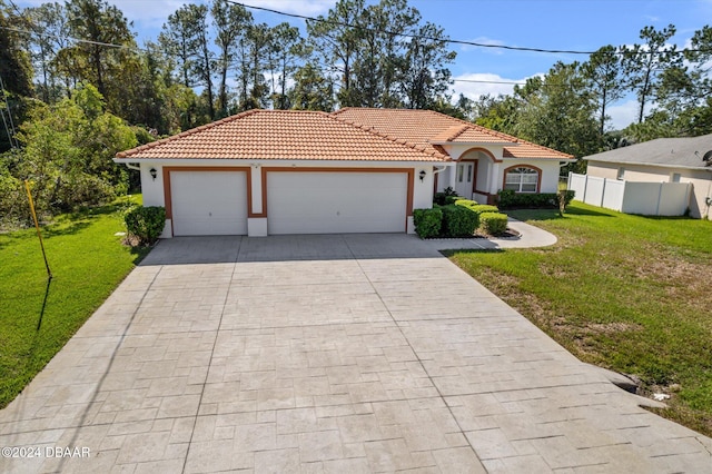 mediterranean / spanish home with a garage and a front yard