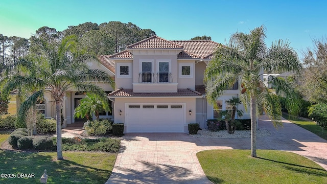 mediterranean / spanish-style home featuring a garage and a front yard