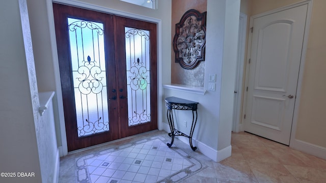 foyer entrance featuring french doors, a healthy amount of sunlight, and light tile patterned flooring