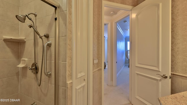 bathroom featuring ornamental molding and tiled shower