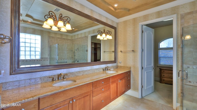 bathroom featuring a tray ceiling, an inviting chandelier, a shower with door, and a healthy amount of sunlight