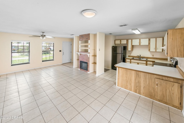 kitchen featuring black fridge, light tile patterned floors, sink, stainless steel range, and ceiling fan