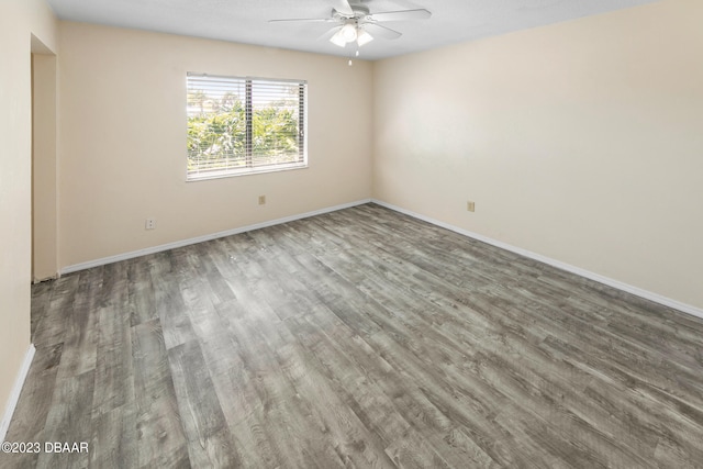 unfurnished room with dark hardwood / wood-style flooring and ceiling fan