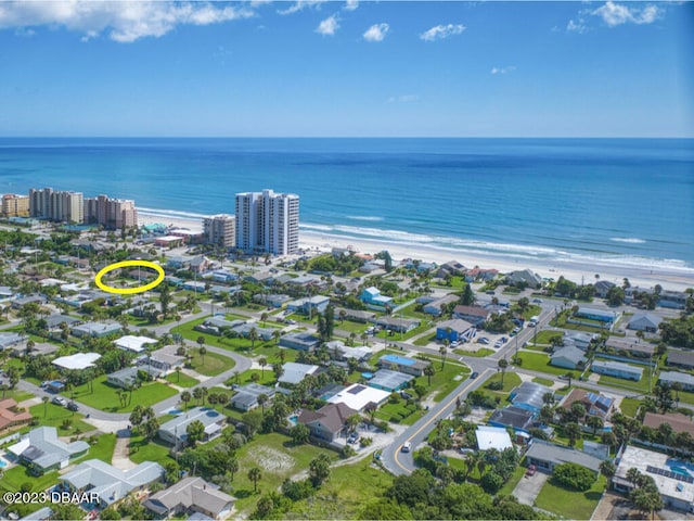 birds eye view of property featuring a beach view and a water view