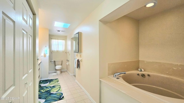 bathroom with vanity, a bath, a skylight, tile patterned floors, and toilet