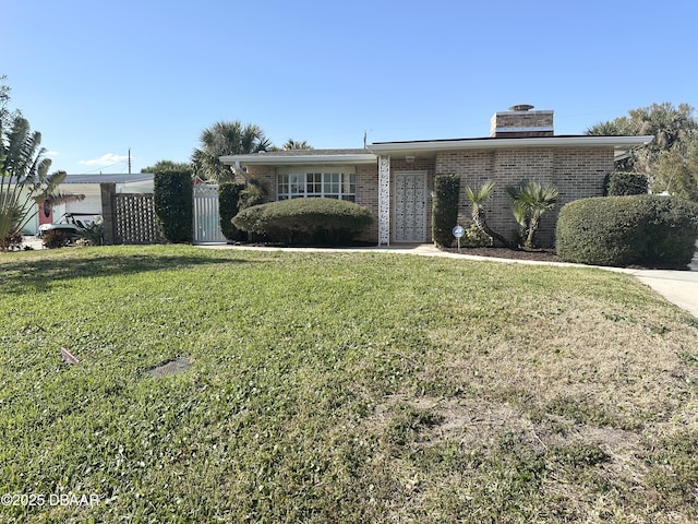 view of front facade with a front lawn and brick siding