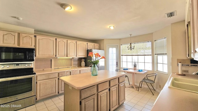 kitchen with visible vents, a sink, light brown cabinetry, light countertops, and stainless steel appliances