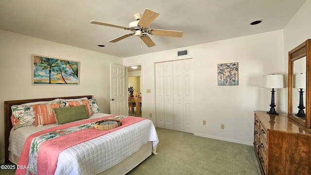 carpeted bedroom featuring a ceiling fan, visible vents, a closet, and baseboards