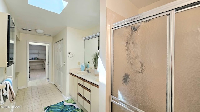 full bath with double vanity, a skylight, a sink, tile patterned flooring, and a shower stall