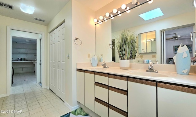 bathroom featuring a skylight, visible vents, and a sink