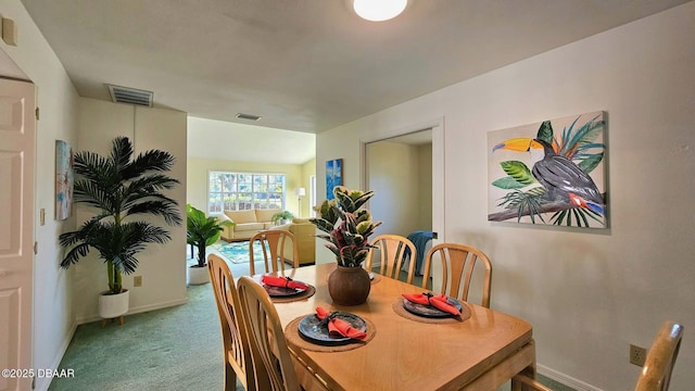 carpeted dining room featuring visible vents and baseboards