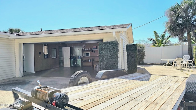 wooden deck featuring a garage and fence