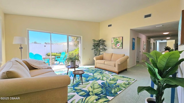 living room with visible vents, light colored carpet, and baseboards