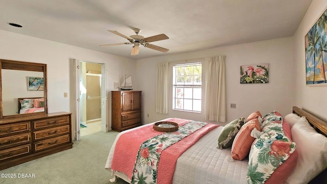 bedroom with light carpet, ensuite bath, and ceiling fan