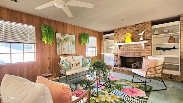 carpeted living room featuring visible vents, built in features, wooden walls, a fireplace, and ceiling fan