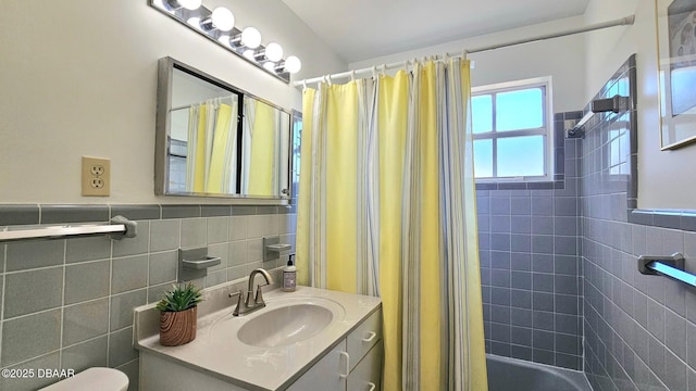 full bathroom featuring toilet, tile walls, vanity, and shower / bathtub combination with curtain