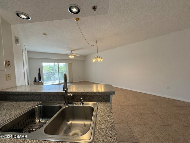 kitchen with sink, tile patterned floors, and a textured ceiling