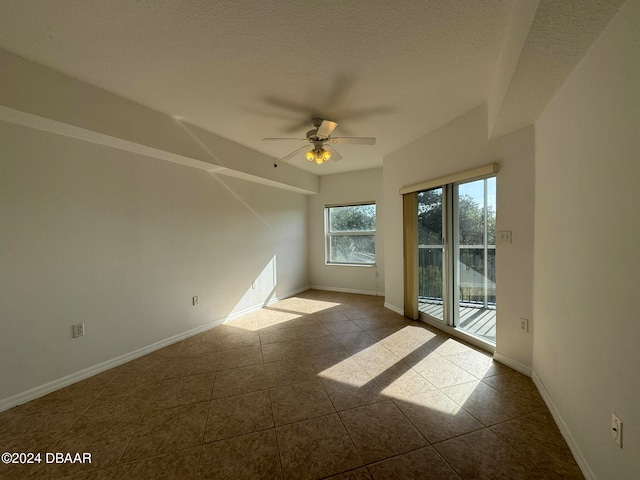 tiled spare room featuring ceiling fan and a textured ceiling